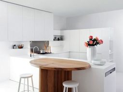 Minimalistic white kitchen with a dining area – by Elmar Studio
