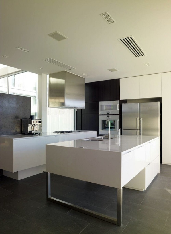 Minimalistic white kitchen with a dining area - by Elmar Studio