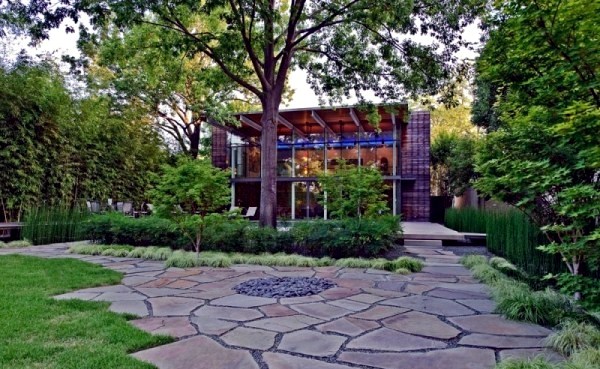 Modern house with windows and garden wall made of recycled glass