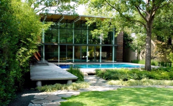 Modern house with windows and garden wall made of recycled glass