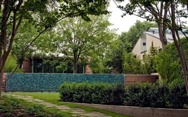 Modern house with windows and garden wall made of recycled glass