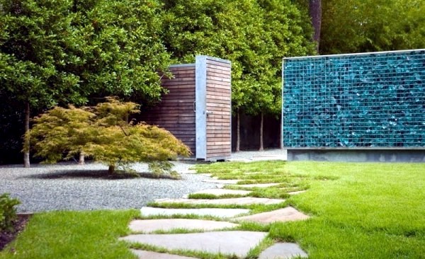 Modern house with windows and garden wall made of recycled glass