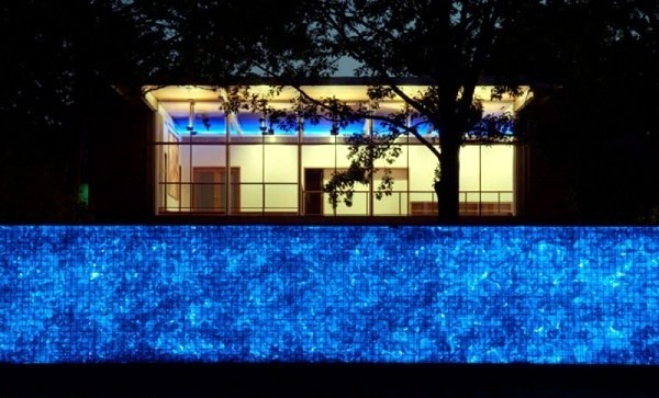 Modern house with windows and garden wall made of recycled glass