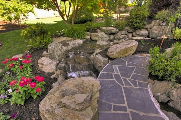Install pebbles and river stones - beautiful landscape in the garden Install pebbles and river stones - beautiful landscape in the garden